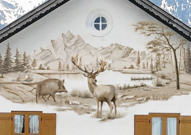 Fassadenmalerei auf Hausgiebel, Motiv: einfarbige Landschaft in Braun-Tönen mit Bergen, Wald, See, Wildschwein und Hirsch