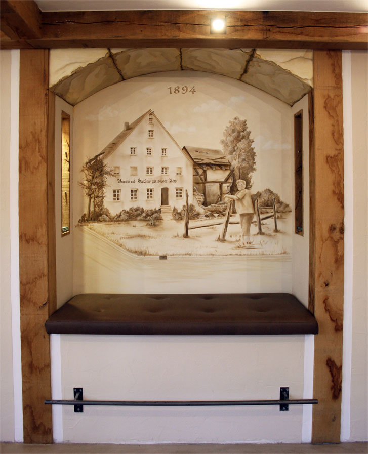 Wandmalerei in Sitznische, Motiv: altes Gasthaus von außen mit Besitzer davor